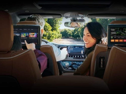 2024 Chrysler Pacifica view of mom in front seat looking back at two children in back seat watching rear tvs