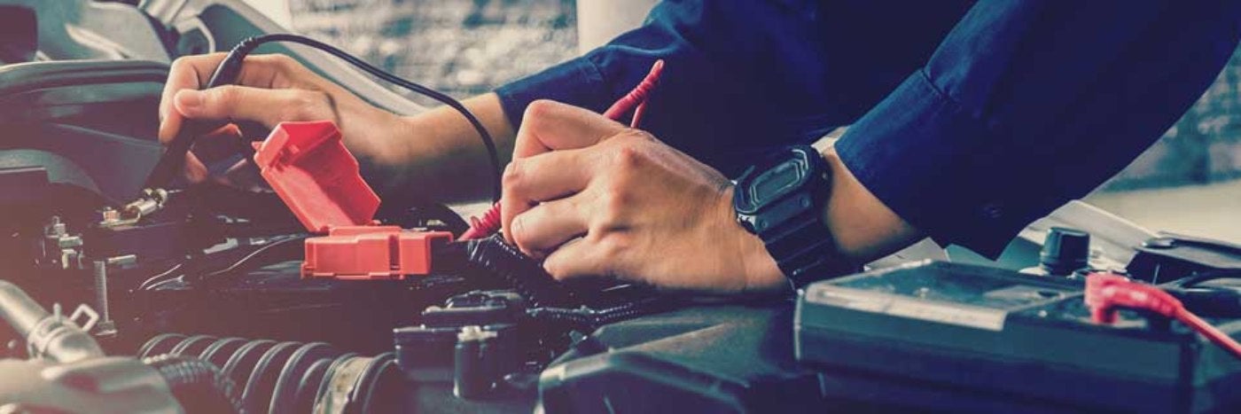 close up view of a service tech inspecting a vehicle's battery